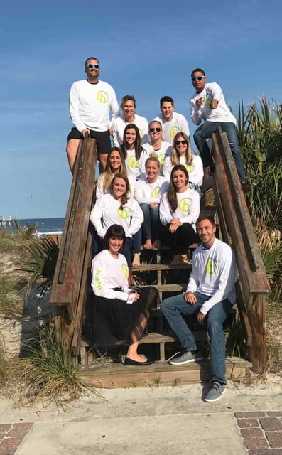 Hueman employees together on the beach pier for a group photo 
