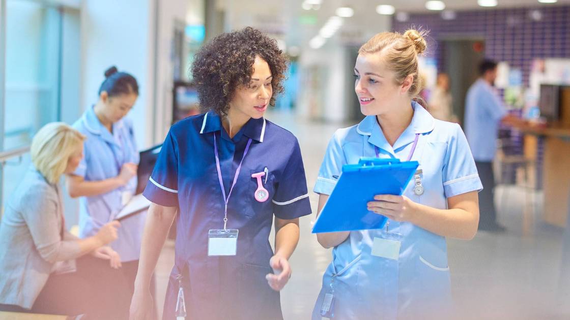 Two medical professionals walking through an academic medical center