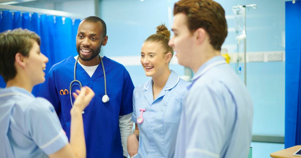 A diverse group of nurses talking in a hospital corridor