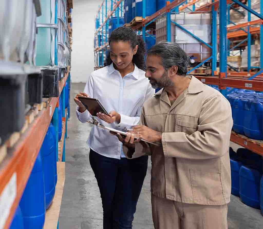 RPO recruiter and warehouse manager collaborating on talent acquisition strategies while reviewing operations.