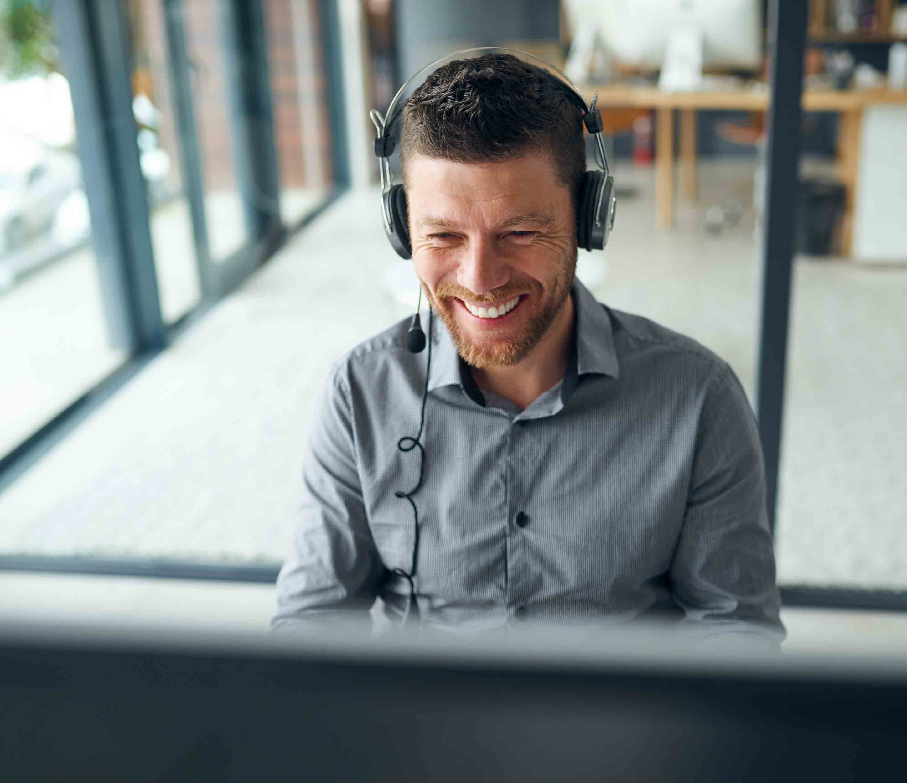 man-call-center-smile-by-computer-consulting-typing-reading-with-voip-agent-headphones-mic-tech-support-telemarketing-happy-customer-care-with-advice-workplace