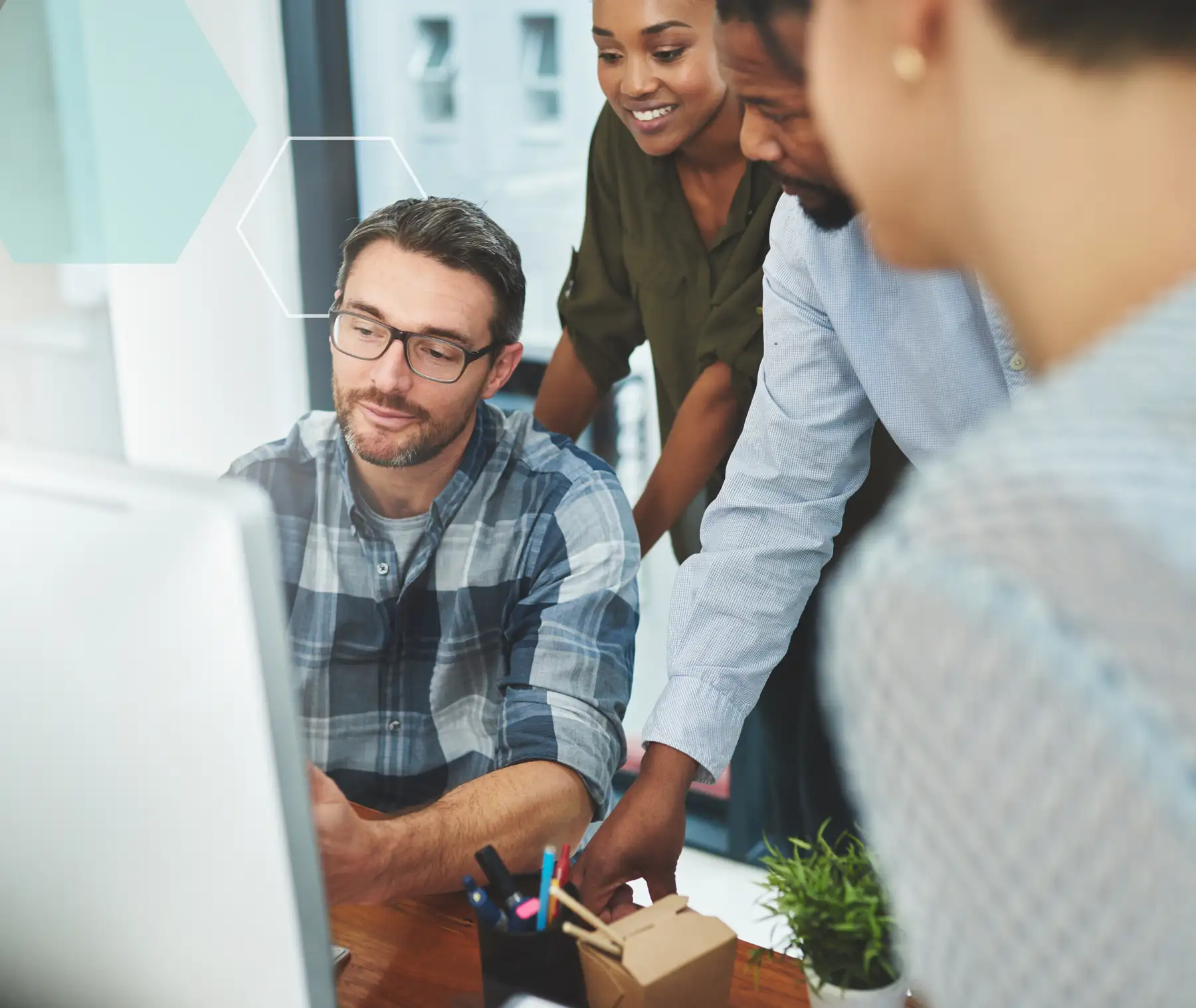 office team collaborating around computer