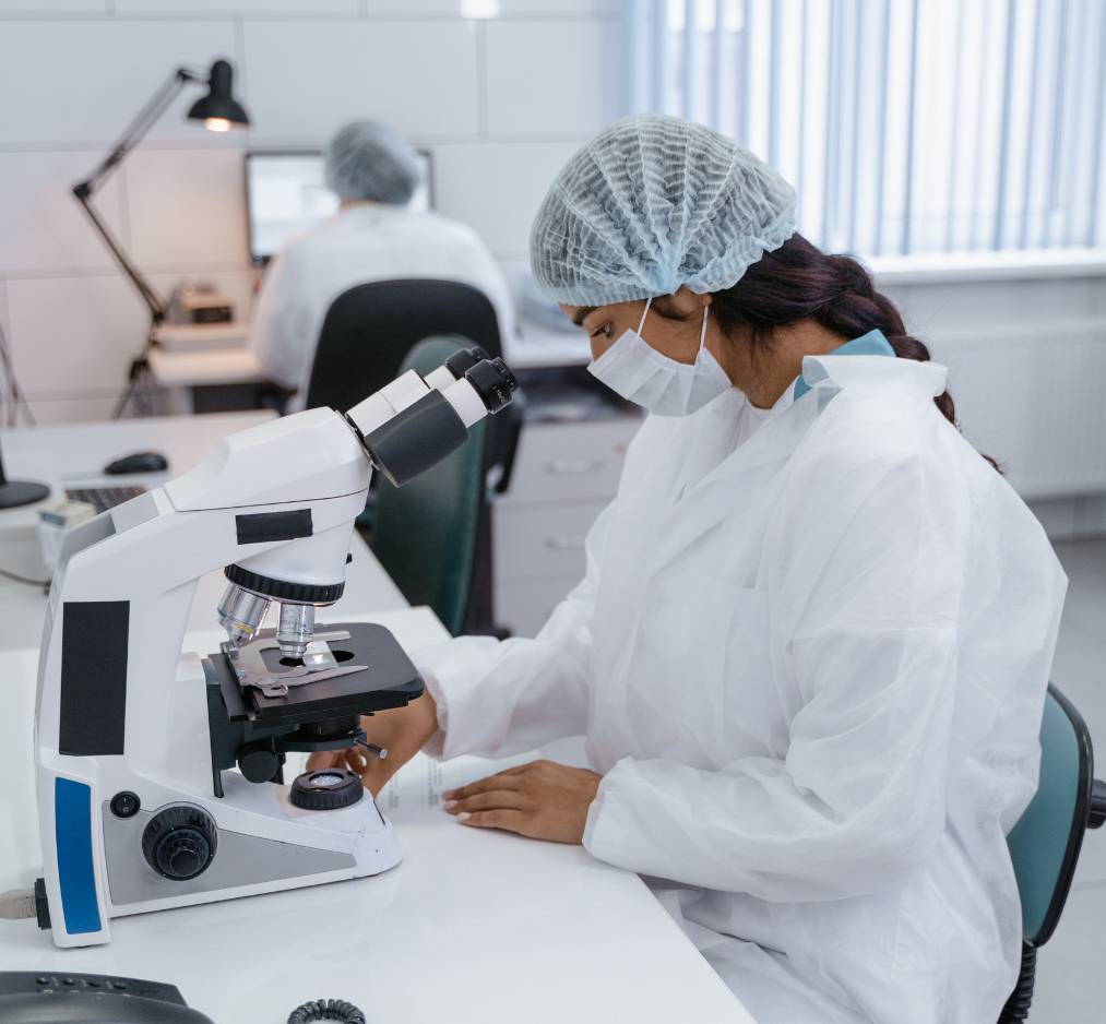 A pharma tech using microscope