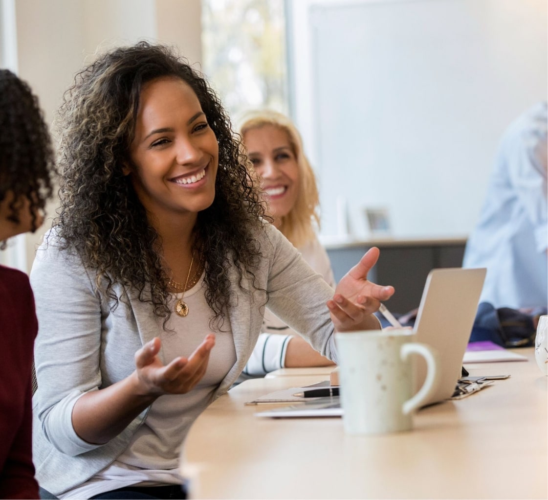 A woman discussing RPO implementation at a table with other people